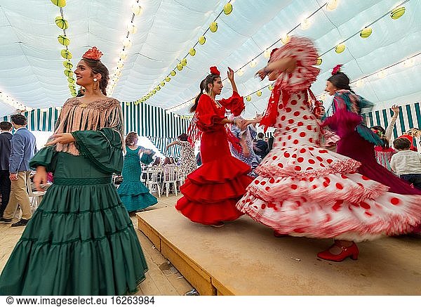 Young woman dancing Sevillano  Spanish woman with flamenco dresses in colourful marquee  Casetas  Feria de Abril  Sevilla  Andalusia  Spain  Europe