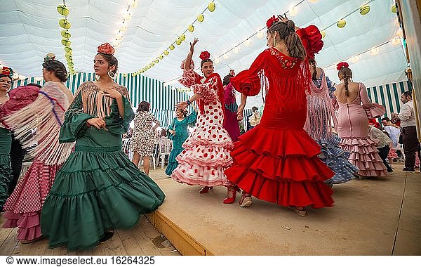 Young woman dancing Sevillano  Spanish woman with flamenco dresses in colourful marquee  Casetas  Feria de Abril  Sevilla  Andalusia  Spain  Europe
