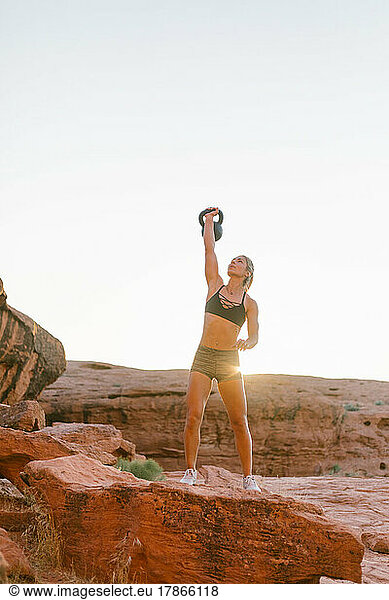 Young woman doing crossfit exercise outdoors in the desert surro