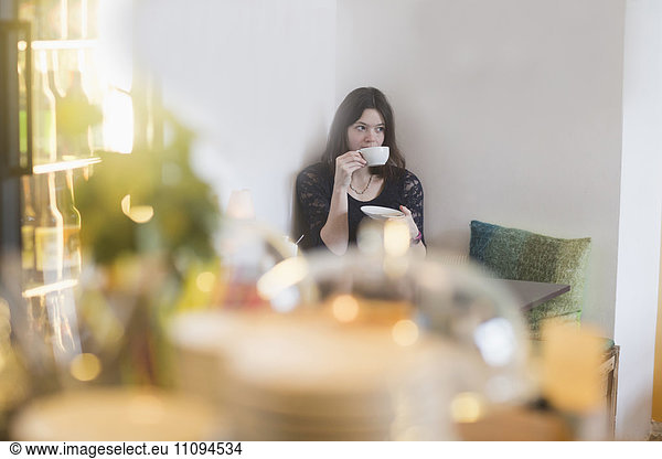 Young woman drinking coffee in coffee shop