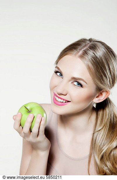 Young woman eating apple