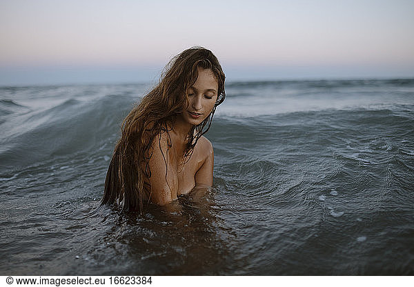 Young woman enjoying in water at beach