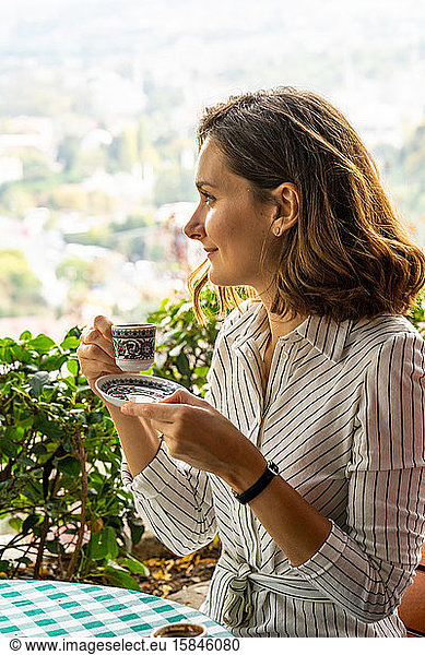 Young woman enjoys a cup of Turkish coffee in Istanbul on vacation