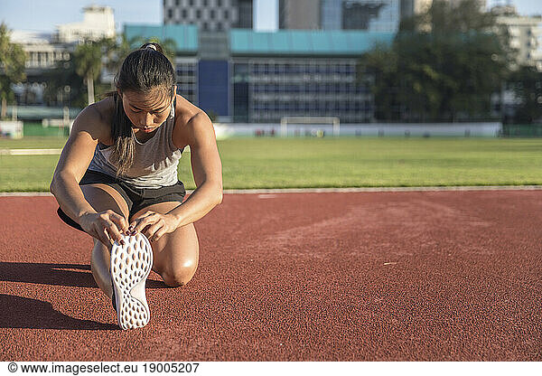 Young woman exercising in sports field