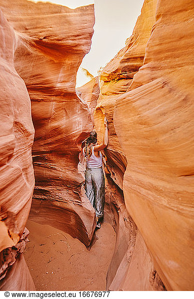 Young woman exploring narrow slot canyons in Escalante  during summer