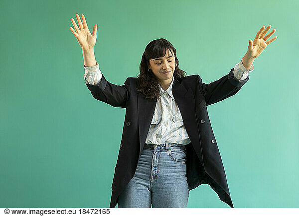 Young woman gesturing against green background