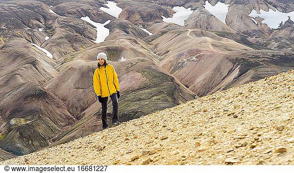 Young woman hiker walking around icelandic highlands and mossy hills