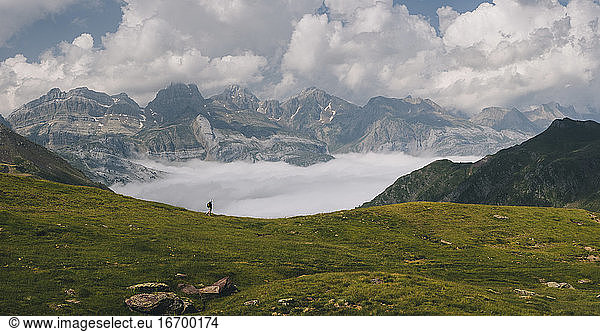 Young woman hiking through Pyrenees with Mount Aspe in the background.