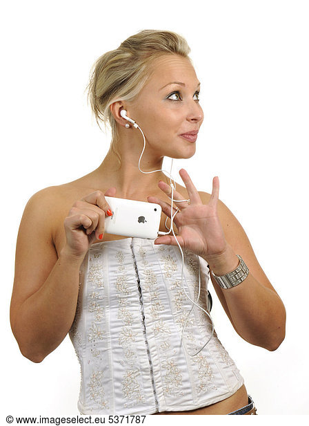 Young woman holding a white Apple iPhone  listening to music with earphones