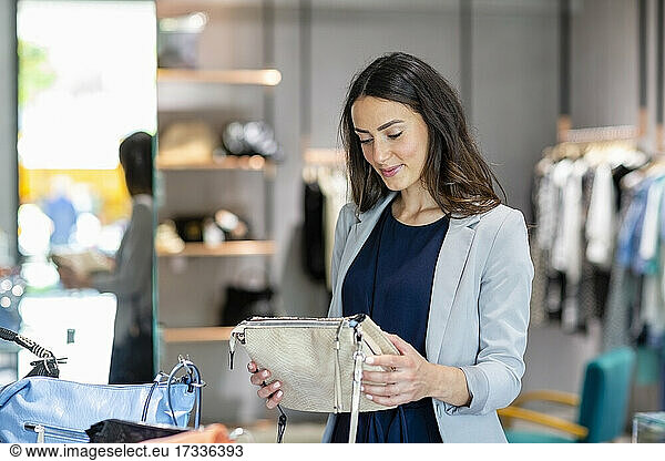 Young woman holding purse while shopping in store