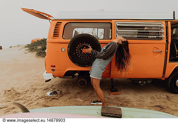 Young woman holding up recreational vehicle tyre at beach  Jalama  California  USA