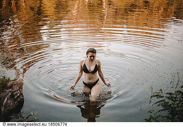 Young woman in a bikini walking in lake