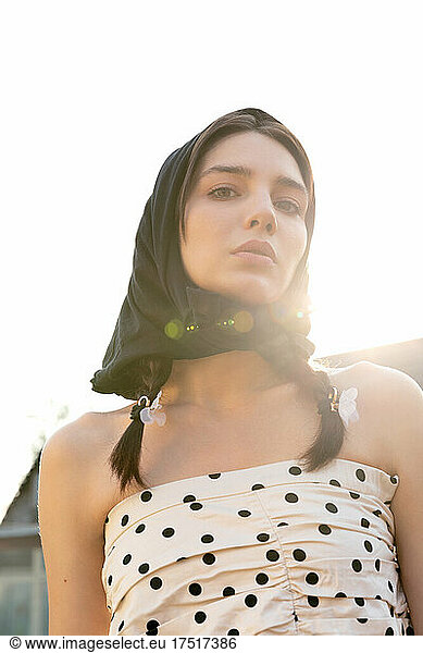 Young woman in a scarf at sunset. Fashion shooting