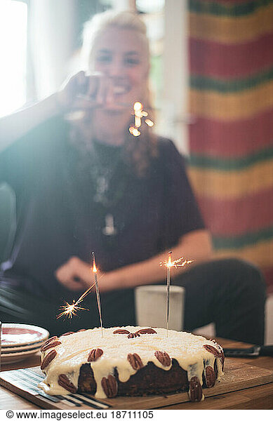 Young woman in Berlin celebrates birthday with sparklers and cake