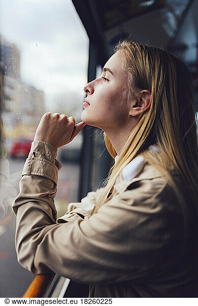 young woman in public transport looking out the window