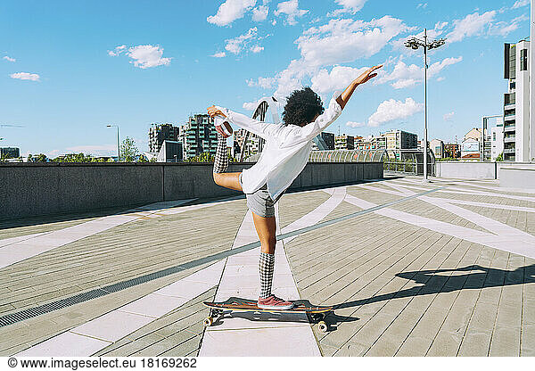 Young woman longboard dancing in city