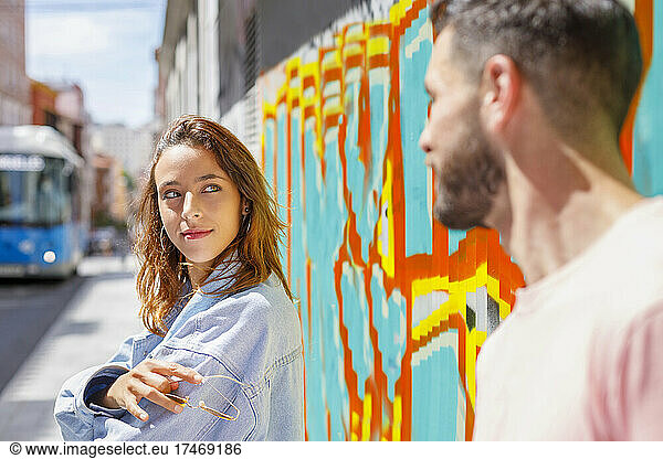 Young woman looking at man on sunny day