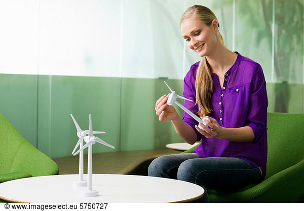 Young woman looking at model of wind turbine