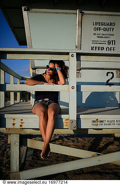 Young woman looking at sea from lifeguard tower
