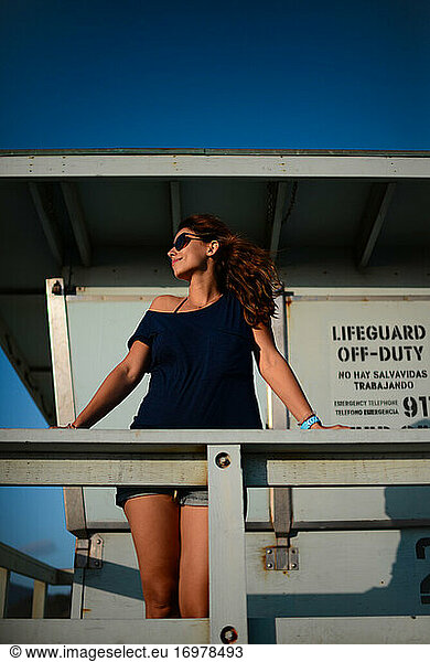 Young woman looking at sea from lifeguard tower