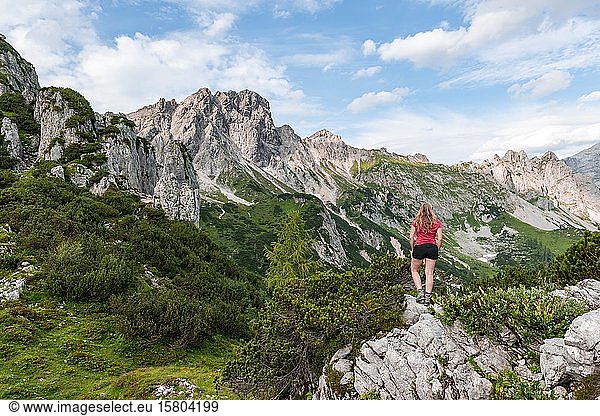 Young woman looking over landscape  rugged peaks  mountains  Armkarwand  Große Bischofsmütze  Salzkammergut  Upper Austria  Austria  Europe