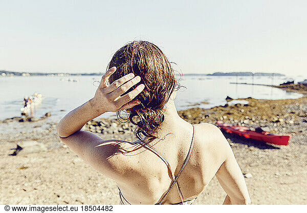 Young woman looks out at Casco Bay after standup paddle board