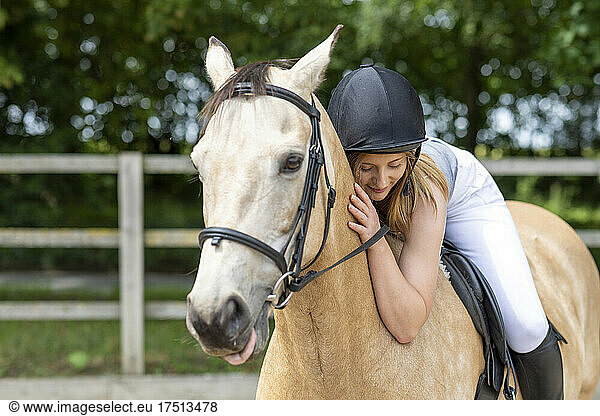 Young woman lying on the back of her horse