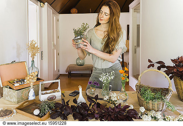 Young woman making floral decoration at home