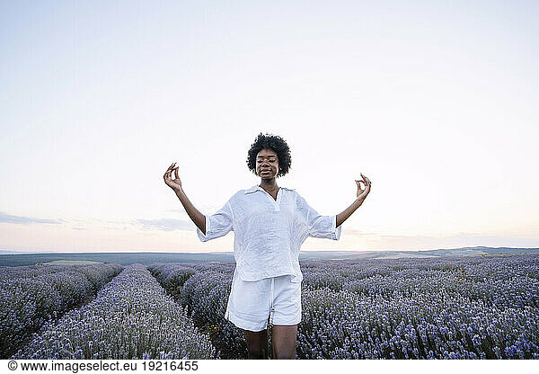 Young woman meditating in lavender field
