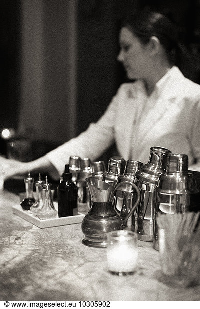 Young woman mixing a cocktail at Piora Restaurant in Manhattan's West Village. Black and white image.