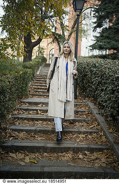 Young woman moving down from stairs in autumn