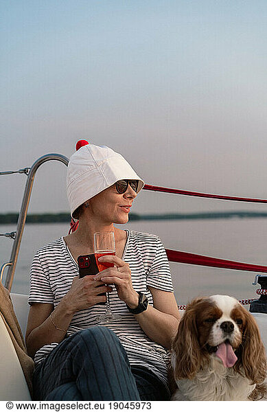 Young woman on a yacht with a dog  Cavalier King Charles Spaniel