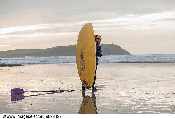 Young woman on beach with sea kayak  Polzeath  Cornwall  England