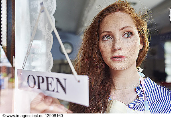 Young woman opening a shop