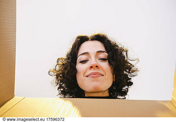 Young woman peeking in box