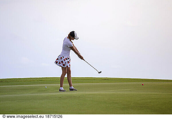 Young woman playing golf against clear white sky  Tanah Lot  Bali  Indonesia