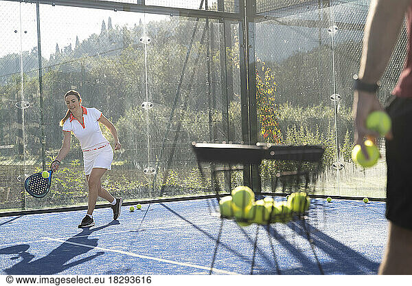Young woman playing paddle tennis at sports court