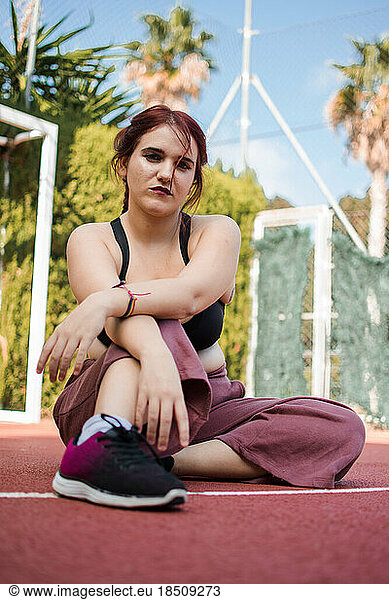 Young woman posing with urban clothes is a basketball court