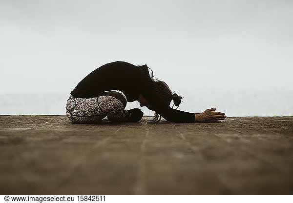 Young woman practicing yoga  asana sitting on the floor of Barcelona