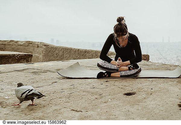 young woman practicing yoga meditating on the floor. Barcelona