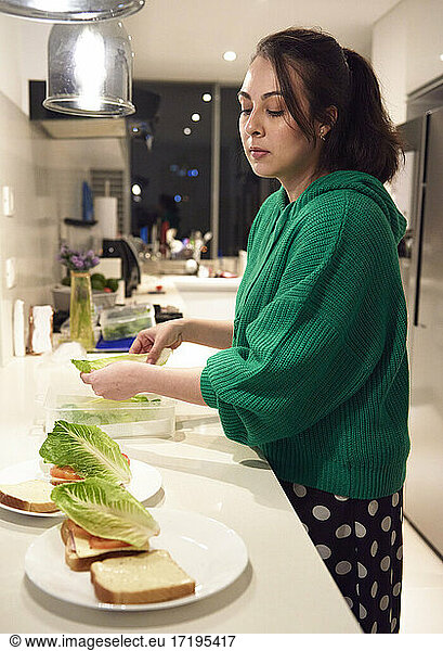 young woman preparing a simple sandwich for food
