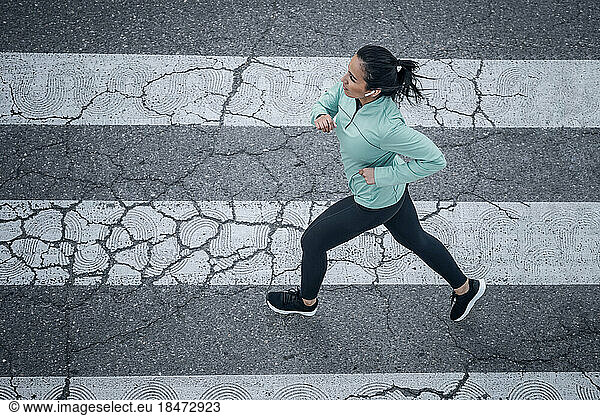Young woman running on road