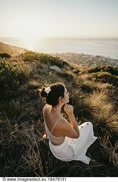 Young woman sitting on Signal Hill at sunset