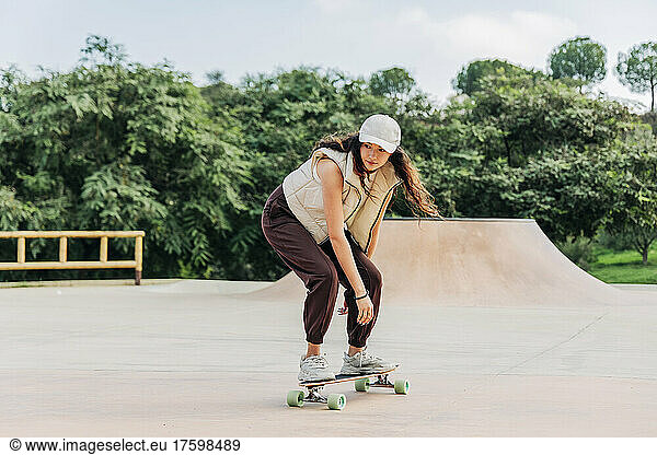 Young woman skateboarding on sports ramp