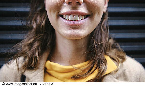 Young woman smiling near shutter