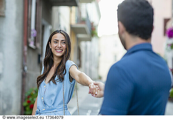 Young woman smiling while holding hand of boyfriend