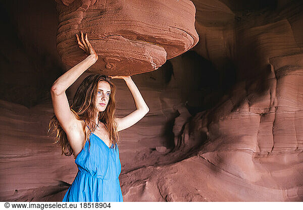 Young woman standing below rock formation in cave