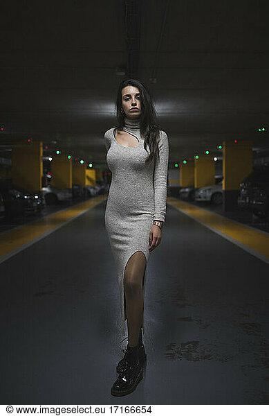 Young woman standing in parking garage at night