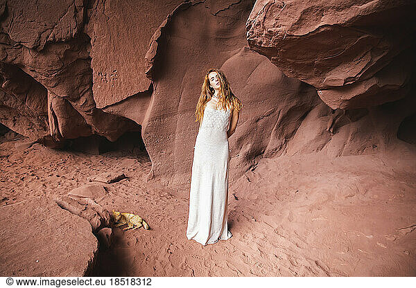 Young woman standing in red cave