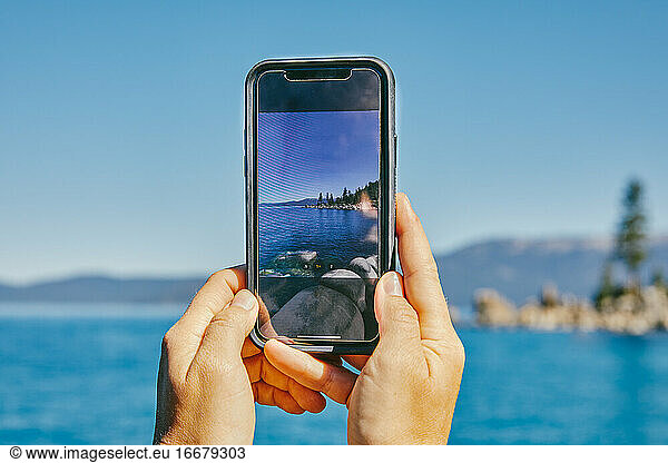 Young woman taking a picture of Lake Tahoe.